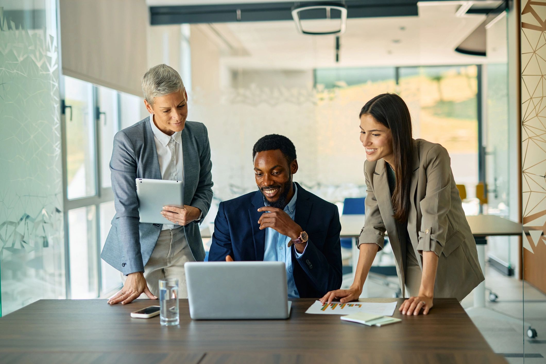 Business team collaborating around a laptop